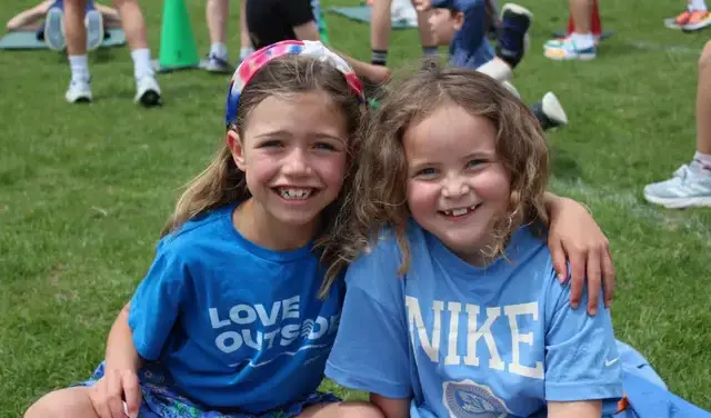 Two lower school girls sitting on grass